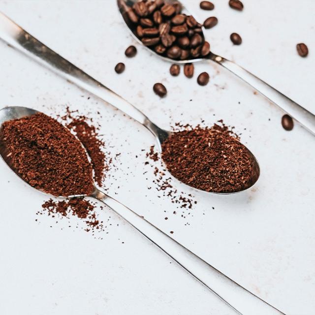 tre skeer med formalet kaffe og kaffebønner til kaffekværne